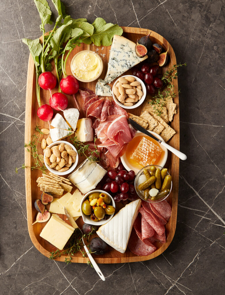 Charcuterie Boards--contain Nuts, Cheeses, Dried Fruits, Jams/Jellies, Crackers and Chocolates, Meats, honey, fresh fruit, carrots and celery.